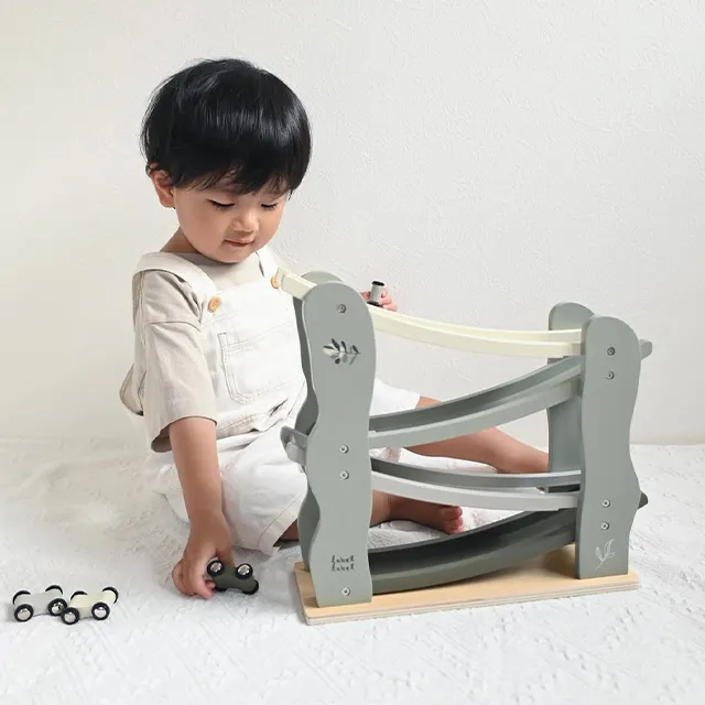 くすみカラーの木のおもちゃで遊ぶ赤ちゃん